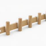 Wooden coat rack with multiple hooks on a white background