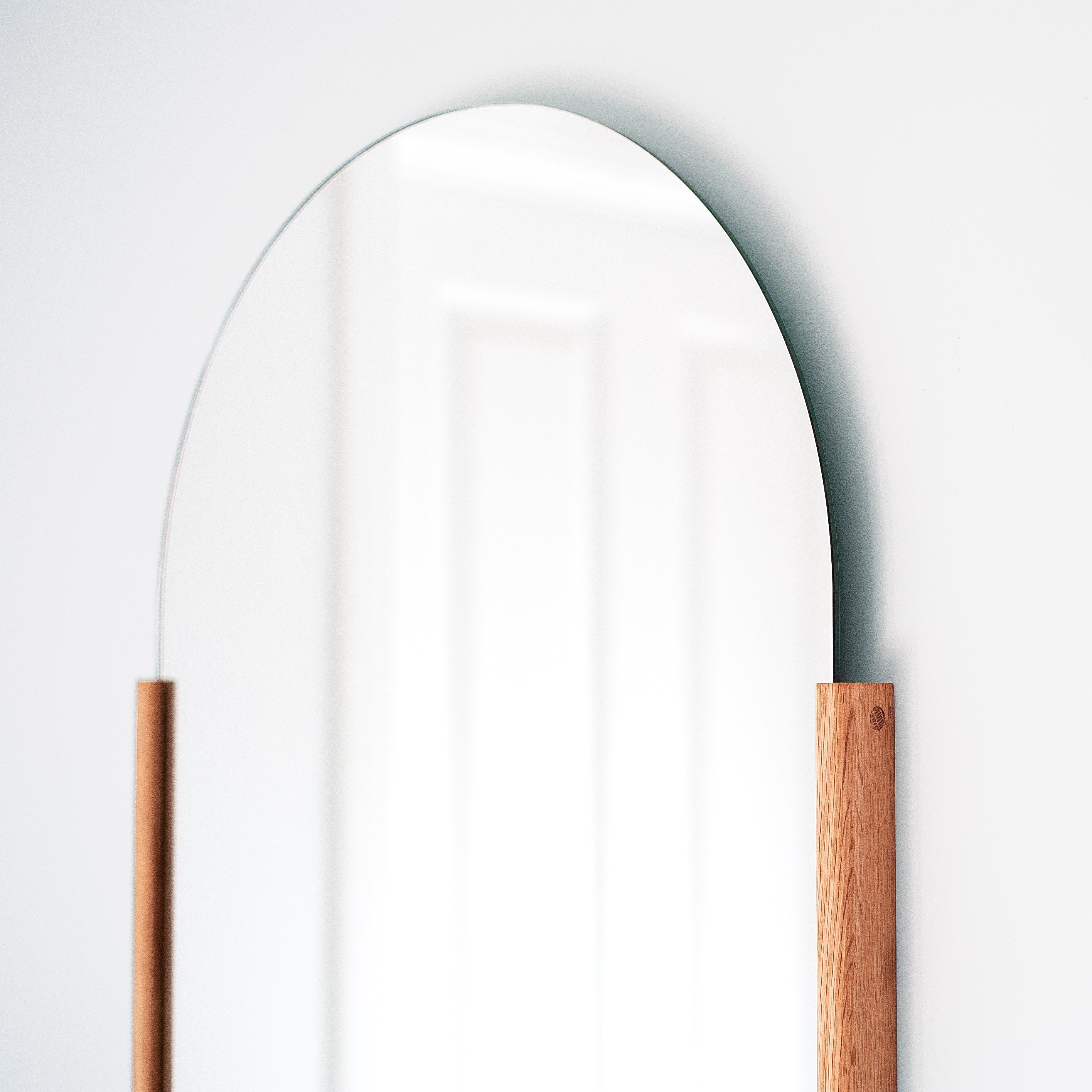 Round mirror with wooden frame on a white background