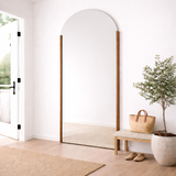 Full-length mirror in a room with a bench, plant, and bag.